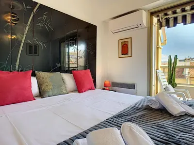 a bedroom with a large white bed with red pillows at Nestor&Jeeves - LA NISSARDE TERRASSE - City center in Nice