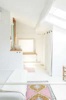 a white room with a bed and a window at Duplex au cœur du vieux Nice in Nice