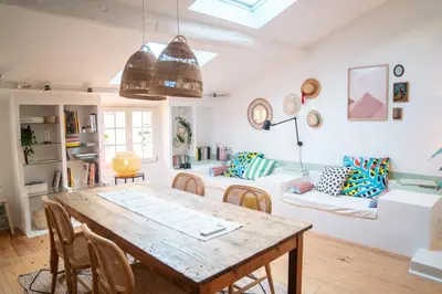 a kitchen and living room with a wooden table and chairs at Duplex au cœur du vieux Nice in Nice