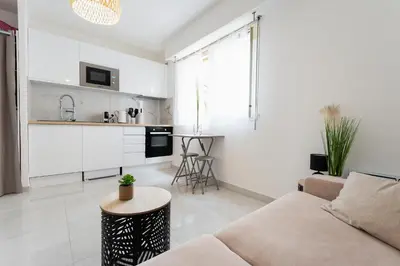 a white living room with a couch and a table at Magnifique Studio à Beaulieu-sur-mer in Beaulieu-sur-Mer