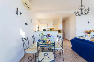 a dining room and kitchen with a table and chairs at VOLTI ON THE BAY AP4386 By Riviera Holiday Homes in Villefranche-sur-Mer