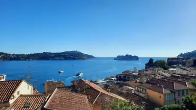 a view of a large body of water with houses at VOLTI ON THE BAY AP4386 By Riviera Holiday Homes in Villefranche-sur-Mer