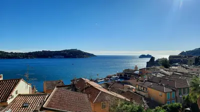 a view of a city and the ocean from above at VOLTI ON THE BAY AP4386 By Riviera Holiday Homes in Villefranche-sur-Mer