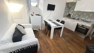 a living room with a white couch and a table at Appartement T2 coconing, WIFI, INTERNET, CLIM, 300m plage in Nice