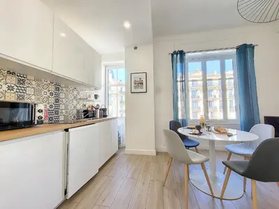 a kitchen and dining room with a table and chairs at Nestor&Jeeves - BLEU BUFFA - Central location in Nice