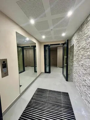 a hallway with glass doors and a brick wall at Appartement neuf coup de coeur entre Èze et Monaco in Èze