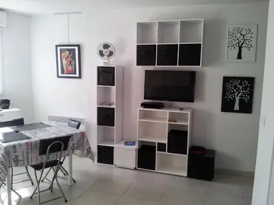 a living room with a tv and a table and a desk at Villa Tobias in Nice
