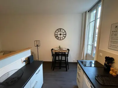a kitchen with a table and a clock on the wall at Charmant Studio - Port de Nice in Nice