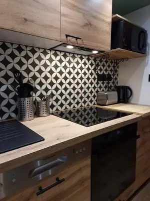 a kitchen with black and white tiles on the wall at Cosy Haven 5 min from Nice Carnival Hyper-Center! in Nice