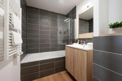 a bathroom with a bath tub and a sink at Nemea Appart Hotel Nice Arenas Aéroport in Nice