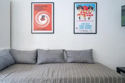 three framed movie posters on a white wall with a couch at Le calme à Nissa la Bella in Nice