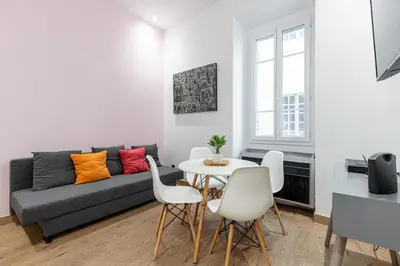 a living room with a couch and a table and chairs at Garibaldi Square - Cozy 1 Bdr Old Town in Nice