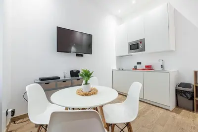 a white kitchen with a white table and chairs at Garibaldi Square - Cozy 1 Bdr Old Town in Nice