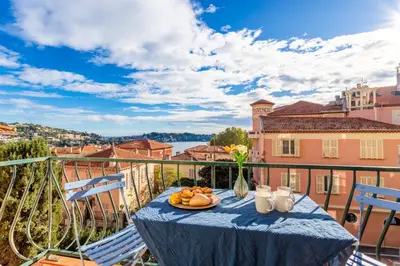 a table with a plate of fruit on a balcony at LE PROVENCE AP4389 By Riviera Holiday Homes in Villefranche-sur-Mer