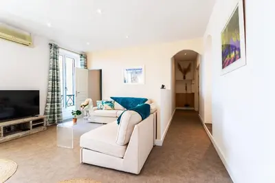 a living room with a couch and a tv at LE PROVENCE AP4389 By Riviera Holiday Homes in Villefranche-sur-Mer