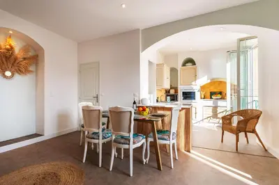a kitchen and dining room with a table and chairs at LE PROVENCE AP4389 By Riviera Holiday Homes in Villefranche-sur-Mer