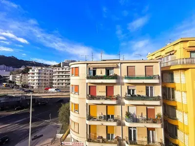 an apartment building with balconies and a parking lot at Studio cosy - Proche mer et gare in Nice