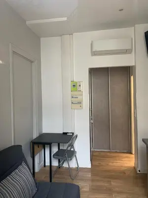 a room with a table and a door with a chair at Studio meublé in Nice