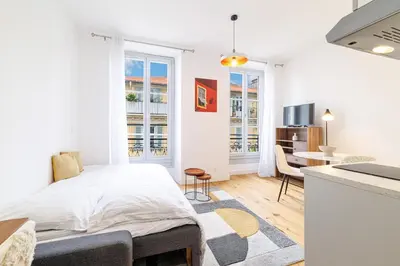a white bedroom with a bed and a kitchen at Charming City Center Studio 406 in Nice