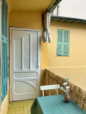 a door to a patio with a table in front of it at Casa Marguerite, studio atypique in Nice
