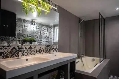 a bathroom with a large sink and a tub at Appartement avec mezzanine in Nice