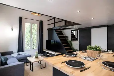 a living room with a blue couch and a staircase at Appartement avec mezzanine in Nice