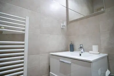 a white bathroom with a sink and a mirror at GuestReady - A peaceful stay near the marina in Nice