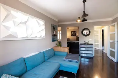 a living room with a blue couch and a kitchen at #39 Old Town suite 3 BDR AC Balcony 5mins Walk to Sea in Nice