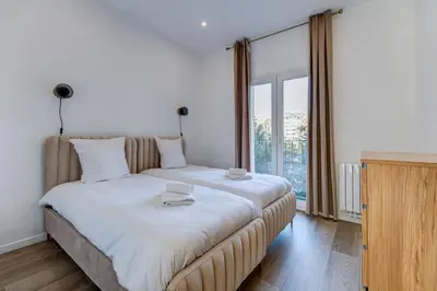 a large bed in a room with a large window at Les Grands Cèdres - Wifi, AC, Parking in Nice