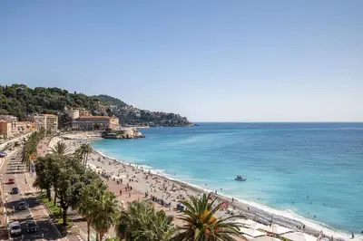 a beach with a lot of people and the ocean at MY CASA - ETAT UNIS 93 INDIGO - Amazing Sea View Aprt with AC in Nice