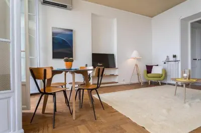 a living room with a table and chairs and a television at MY CASA - ETATS UNIS 894 - Stunning on Sea Front w AC in Nice
