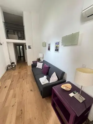 a living room with a couch and a table at Magnifique Duplex Type Loft in Nice