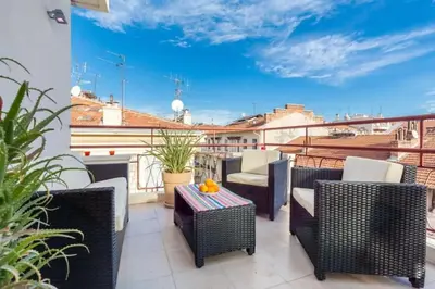 a balcony with wicker chairs and tables on a roof at MY CASA - DALPOZZO - 5min walk to beach in Nice