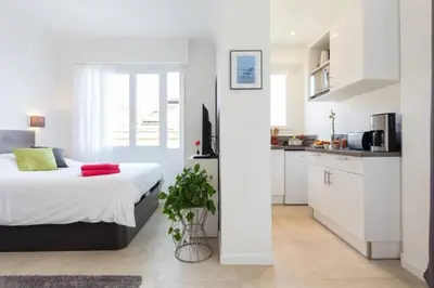 a white bedroom with a bed and a kitchen at MY CASA - DALPOZZO - 5min walk to beach in Nice