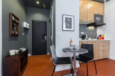 a kitchen with a table and chairs in a room at MY CASA - DROITE - Bright studio in the Old Town in Nice