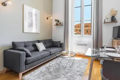 a living room with a couch and a glass table at MY CASA - DELOYE - Spacious Quiet studio w AC near Old Town in Nice