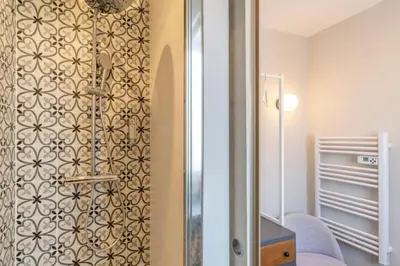 a bathroom with a shower with a wall at MY CASA - LAMARTINE - Studio w terrace and AC Very central in Nice