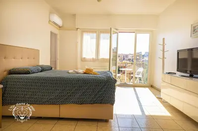 a bedroom with a bed and a tv and a balcony at l'Or dans la Mer 3 in Nice