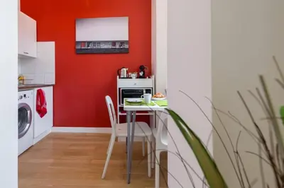 a kitchen with red walls and a table with chairs at MASSENA 33 - Cosy Studio City Center in Nice