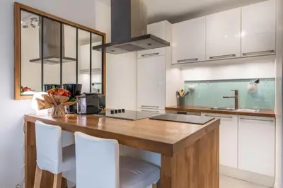 a kitchen with a wooden table and white cabinets at MY CASA - ROSSINI - Central and cosy with AC in Nice