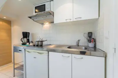 a kitchen with white cabinets and a sink at MY CASA - PORT 1 - Spacious and central w AC on the Port in Nice