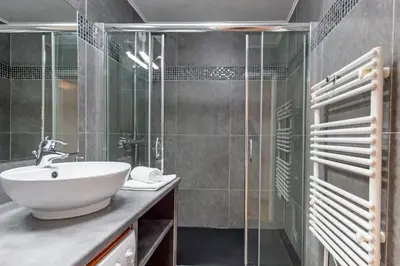 a bathroom with a sink and a glass shower at Appartement rénové - Terrasse - Parking - BM in Nice