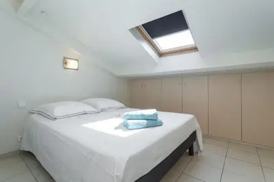 a bedroom with a large white bed with a skylight at MY CASA - PORT 3 - Spacious and central w AC on the Port in Nice
