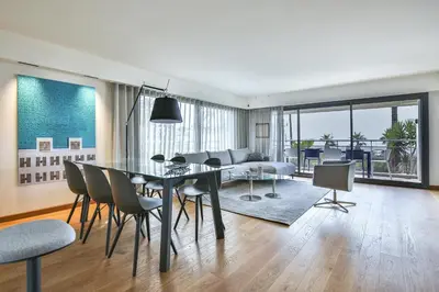 a dining room and living room with a table and chairs at Sublime Appartement Promenade des Anglais (1) in Nice