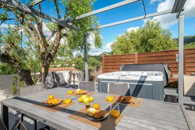 a wooden table with fruit on it on a patio at Villa vue mer, terrasse et spa in Nice