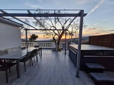 a deck with tables and chairs on a roof at Villa vue mer, terrasse et spa in Nice
