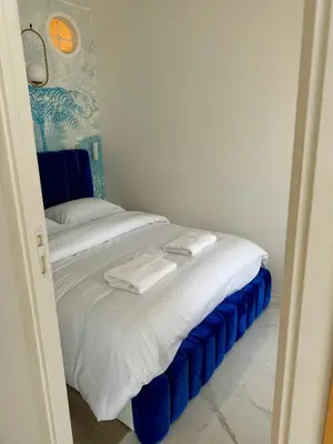 a bed with blue and white sheets and pillows at L'appartement Azur in Nice