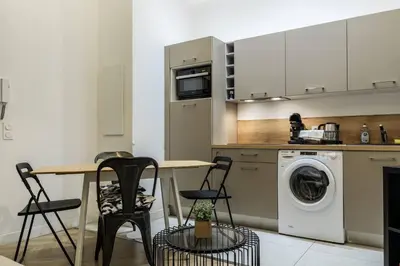 a kitchen with a table and a washing machine at Joli 2 pièces au port de Nice in Nice