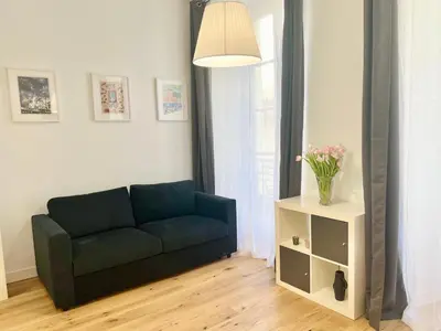 a living room with a couch and a table with flowers at Confortable central Studio to discover Nice in Nice