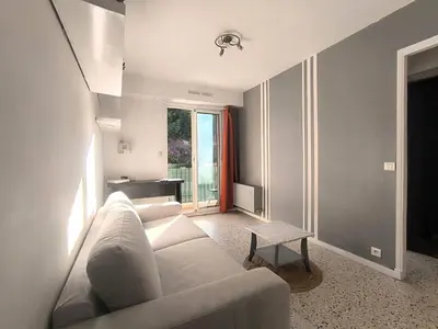 a living room with a white couch and a table at F1 - 8MIN DE LA PLAGE - 5MIN TRAMWAY in Nice